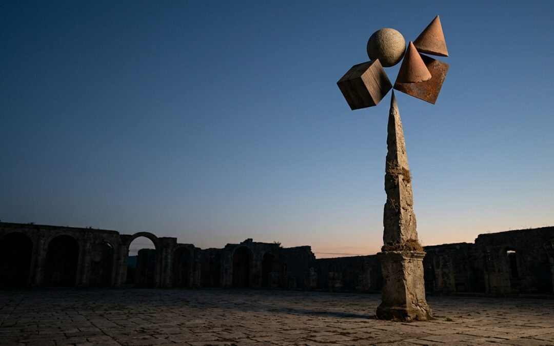 Pilar de piedra con cuatro objetos distintos girando sobre su punta, imagen de la areté y de las cuatro virtudes cardinales de los estoicos.